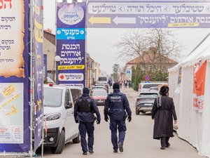Zdjęcie przedstawia zabezpieczenie pielgrzymki Chasydów do Leżajska. Na zdjęciach znajdują się umundurowani funkcjonariusze Policji oraz pielgrzymi narodowości żydowskiej.