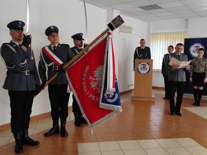 Zdjęcie przedstawia funkcjonariuszy leżajskiej komendy podczas uroczystej zbiórki. Na zdjęciu widać salutujący poczet sztandarowy.