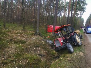 Zdjecia przedstawiają ciągnik rolniczy wraz z wozem. Pojazd znajduje się w rowie.