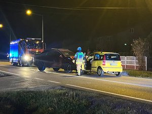 Zdjęcie przedstawia dwa pojazdy, które zderzyły się czołowo. Są to samochody marek Ssang Yong oraz Fiat. Na zdjęciu panuje mrok. Widać refleksy niebieskich świateł błyskowych. Na dalszym planie widać wozy Państwowej Straży Pożarnej.