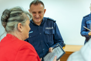 Zdjęcie przedstawia umundurowanego funkcjonariusza - Komendanta Powiatowego Policji w Leżajsku podczas wręczania wyróżnień.