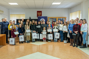 Zdjęcie grupowe osób biorących udział w wydarzeniu rozdania nagród laureatom konkursu &quot;Bezpieczne wakacje 2023&quot;.