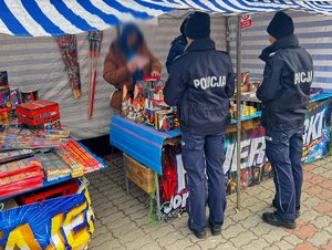 Zdjęcia przedstawiają umundurowanych funkcjonariuszy policji podczas kontroli stoisk, na których prowadzona jest sprzedaż fajerwerków.