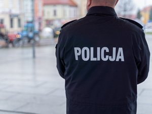 Zdjęcie przedstawia umundurowanych funkcjonariuszy z Komendy Powiatowej Policji w Leżajsku oraz pojazdy służbowe oznakowane, biorące udział w zabezpieczeniu protestu rolników w dniu dwudziestego lutego. W tle widać pojazdy oraz maszyny rolnicze.