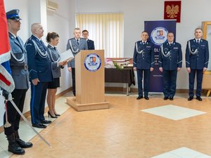 Zdjęcie przedstawia funkcjonariuszy Policji ubranych w umundurowanie wyjściowe podczas uroczystej zbiórki z okazji pożegnania ze sztandarem leżajskiej jednostki dotychczasowego Komendanta Powiatowego Policji, inspektora Janusza Mokrzyckiego. Na zdjęciach widoczny jest poczet sztandarowy, Zastępca Komendanta Wojewódzkiego Policji w Rzeszowie inspektor Jacek Juwa, a także nowy przełożony leżajskich policjantów podinspektor Ryszard Tyka. Na zdjęciach widoczni są również samorządowcy oraz przedstawiciele innych służb mundurowych.