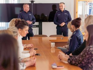 Zdjęcie przedstawia kadrę kierowniczą Komendy Powiatowej Policji w Leżajsku, w tym Komendanta podinspektora Ryszarda Tykę. Są oni ubrani w mundury policyjne. Stoją frontem do obiektywu. Na pierwszym planie widoczne są Panie, które w chwili robienia zdjęcia siedzą.