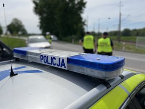 Na zdjęciu widoczni są umundurowani funkcjonariusze Policji i Straży Ochrony Kolei. Zdjęcie wykonane na zewnątrz.