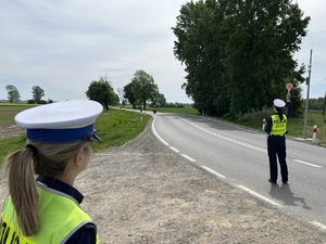 Na zdjęciu widoczni są umundurowani funkcjonariusze Policji. Zdjęcie wykonane na zewnątrz.