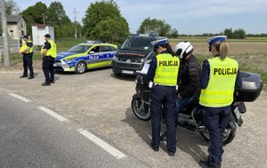 Na zdjęciu widoczni są umundurowani funkcjonariusze Policji i Straży Ochrony Kolei. Zdjęcie wykonane na zewnątrz.