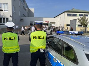 Zdjęcia przedstawiają umundurowanych funkcjonariuszy Komendy Powiatowej Policji w Leżajsku, którzy znajdują się pod szkołami na terenie powiatu leżajskiego i rozmawiają z uczestnikami ruchu drogowego, którzy korzystają z przejścia dla pieszych. Policjanci ubrani są w odblaskowe kamizelki.