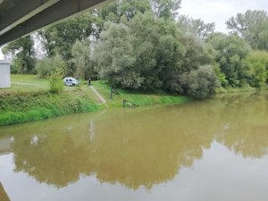 Zdjęcia przedstawiają umundurowanego funkcjonariusza oraz oznakowany radiowóz Policji podczas działań mających na celu monitorowanie stanu rzek i potoków na terenie powiatu leżajskiego.