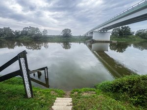 Zdjęcia przedstawiają umundurowanego funkcjonariusza oraz oznakowany radiowóz Policji podczas działań mających na celu monitorowanie stanu rzek i potoków na terenie powiatu leżajskiego.