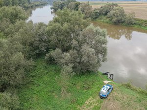 Zdjęcia przedstawiają umundurowanego funkcjonariusza oraz oznakowany radiowóz Policji podczas działań mających na celu monitorowanie stanu rzek i potoków na terenie powiatu leżajskiego.