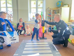 Zdjęcia przedstawiają umundurowanych funkcjonariuszy Policji podczas spotkania z dziećmi z jednego z leżajskich przedszkoli. Na zdjęciach widoczne jest tak zwane Miasteczko Ruchu Drogowego, które policjanci wykorzystują podczas zajęć z najmłodszymi.