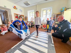 Zdjęcia przedstawiają umundurowanych funkcjonariuszy Policji podczas spotkania z dziećmi z jednego z leżajskich przedszkoli. Na zdjęciach widoczne jest tak zwane Miasteczko Ruchu Drogowego, które policjanci wykorzystują podczas zajęć z najmłodszymi.