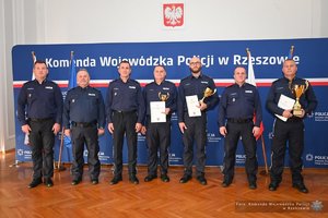 Zdjęcia przedstawiają umundurowanych funkcjonariuszy Policji w trakcie przebiegu eliminacji do ogólnopolskiego konkursu służby dyżurnej. Na zdjęciach widać zmagania policjantów podczas testów i zadań praktycznych. Wszystko odbywa się w zamkniętej sali konferencyjnej.