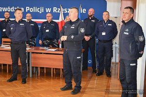 Zdjęcia przedstawiają umundurowanych funkcjonariuszy Policji w trakcie przebiegu eliminacji do ogólnopolskiego konkursu służby dyżurnej. Na zdjęciach widać zmagania policjantów podczas testów i zadań praktycznych. Wszystko odbywa się w zamkniętej sali konferencyjnej.