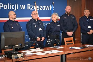 Zdjęcia przedstawiają umundurowanych funkcjonariuszy Policji w trakcie przebiegu eliminacji do ogólnopolskiego konkursu służby dyżurnej. Na zdjęciach widać zmagania policjantów podczas testów i zadań praktycznych. Wszystko odbywa się w zamkniętej sali konferencyjnej.