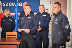 Zdjęcia przedstawiają umundurowanych funkcjonariuszy Policji w trakcie przebiegu eliminacji do ogólnopolskiego konkursu służby dyżurnej. Na zdjęciach widać zmagania policjantów podczas testów i zadań praktycznych. Wszystko odbywa się w zamkniętej sali konferencyjnej.