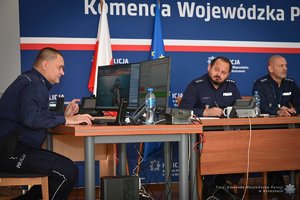 Zdjęcia przedstawiają umundurowanych funkcjonariuszy Policji w trakcie przebiegu eliminacji do ogólnopolskiego konkursu służby dyżurnej. Na zdjęciach widać zmagania policjantów podczas testów i zadań praktycznych. Wszystko odbywa się w zamkniętej sali konferencyjnej.