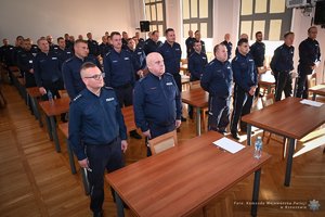 Zdjęcia przedstawiają umundurowanych funkcjonariuszy Policji w trakcie przebiegu eliminacji do ogólnopolskiego konkursu służby dyżurnej. Na zdjęciach widać zmagania policjantów podczas testów i zadań praktycznych. Wszystko odbywa się w zamkniętej sali konferencyjnej.