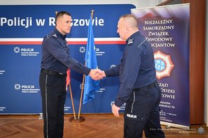 Zdjęcia przedstawiają umundurowanych funkcjonariuszy Policji w trakcie przebiegu eliminacji do ogólnopolskiego konkursu służby dyżurnej. Na zdjęciach widać zmagania policjantów podczas testów i zadań praktycznych. Wszystko odbywa się w zamkniętej sali konferencyjnej.