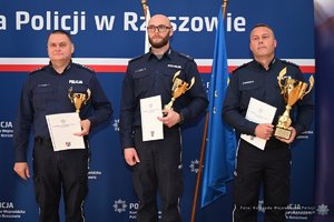 Zdjęcia przedstawiają umundurowanych funkcjonariuszy Policji w trakcie przebiegu eliminacji do ogólnopolskiego konkursu służby dyżurnej. Na zdjęciach widać zmagania policjantów podczas testów i zadań praktycznych. Wszystko odbywa się w zamkniętej sali konferencyjnej.