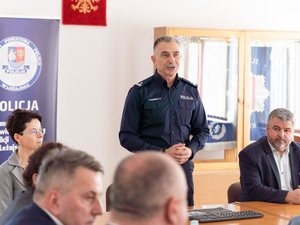 Zdjęcia przedstawia funkcjonariuszy policji wraz z samorządowcami, prokuratorem, sędzią oraz strażakiem podczas odprawy rocznej w leżajskiej komendzie. Odprawa odbyła się w budynku Komendy Powiatowej Policji w Leżajsku. Na zdjęciach znajdują się policjanci oraz osoby cywilne. Widoczny jest telewizor na którym wyświetlana jest prezentacja.