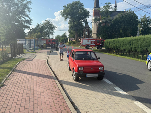 Zdjęcie przedstawia miejsce zdarzenia drogowego w Giedlarowej. Na zdjęciu widoczne są pojazdy straży, policji.