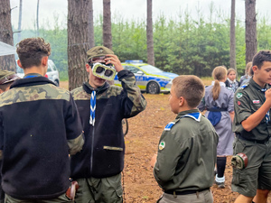 Zdjęcia przedstawiają spotkanie profilaktyczne policjantów z uczestnikami obozu harcerskiego w Dąbrowicy.