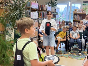 Zdjęcie przedstawiają przebieg spotkania policjantów z leżajskiej komendy z dziećmi w gminnej bibliotece publicznej w Brzózie Królewskiej. Na zdjęciach widać umundurowanych funkcjonariuszy oraz dzieci, które przy pomocy mobilnego miasteczka ruchu drogowego ćwiczyli prawidłowe zachowania w ruchu drogowym.