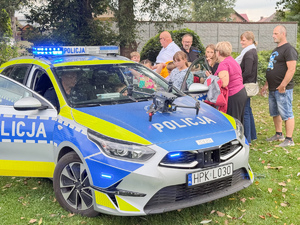 Zdjęcia przedstawiają policjantów z leżajskiej komendy podczas pikniku &quot;Święto Pieczonego Ziemniaka&quot;, który odbył się w Brzózie Królewskiej. Na zdjęciach są widoczni umundurowani policjanci oraz dzieci, które znajdowały się w radiowozie.