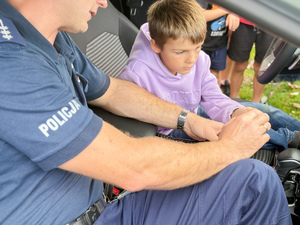 Zdjęcia przedstawiają policjantów z leżajskiej komendy podczas pikniku &quot;Święto Pieczonego Ziemniaka&quot;, który odbył się w Brzózie Królewskiej. Na zdjęciach są widoczni umundurowani policjanci oraz dzieci, które znajdowały się w radiowozie.