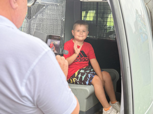 Zdjęcia przedstawiają policjantów z leżajskiej komendy podczas pikniku &quot;Święto Pieczonego Ziemniaka&quot;, który odbył się w Brzózie Królewskiej. Na zdjęciach są widoczni umundurowani policjanci oraz dzieci, które znajdowały się w radiowozie.