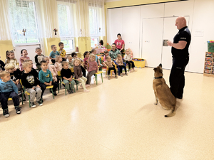 Zdjęcia przedstawiają psa służbowego wraz z przewodnikiem podczas zajęć profilaktycznych w przedszkolu.