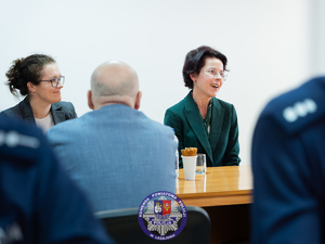 Zdjęcia przedstawiają przebieg odprawy rocznej w auli Komendy Powiatowej Policji w Leżajsku. Na zdjęciach widać umundurowanych funkcjonariuszy oraz osoby cywilne - zaproszonych gości, przedstawicieli samorządów powiatu leżajskiego. Zdjęcia wykonane są wewnątrz budynku.