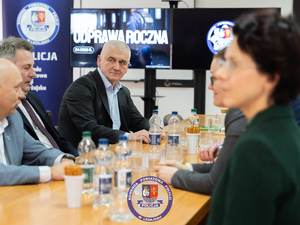 Zdjęcia przedstawiają przebieg odprawy rocznej w auli Komendy Powiatowej Policji w Leżajsku. Na zdjęciach widać umundurowanych funkcjonariuszy oraz osoby cywilne - zaproszonych gości, przedstawicieli samorządów powiatu leżajskiego. Zdjęcia wykonane są wewnątrz budynku.