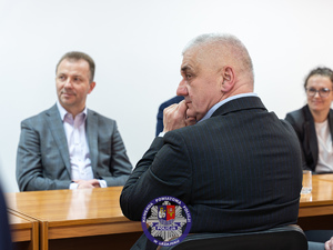 Zdjęcia przedstawiają przebieg odprawy rocznej w auli Komendy Powiatowej Policji w Leżajsku. Na zdjęciach widać umundurowanych funkcjonariuszy oraz osoby cywilne - zaproszonych gości, przedstawicieli samorządów powiatu leżajskiego. Zdjęcia wykonane są wewnątrz budynku.