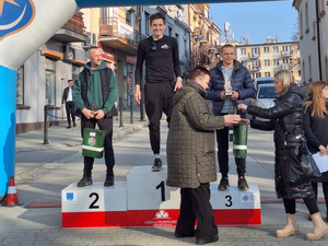 Zdjęcie przedstawia oprawę na zakończenie biegu Tropem Wilczym w Przeworsku oraz statuetkę.