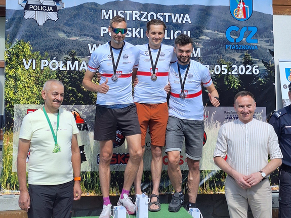 Zdjęcie przedstawiają leżajskiego policjanta Bartosza Ceberaka podczas dekoracji po biegu górskim. Mężczyzna stoi na podium.